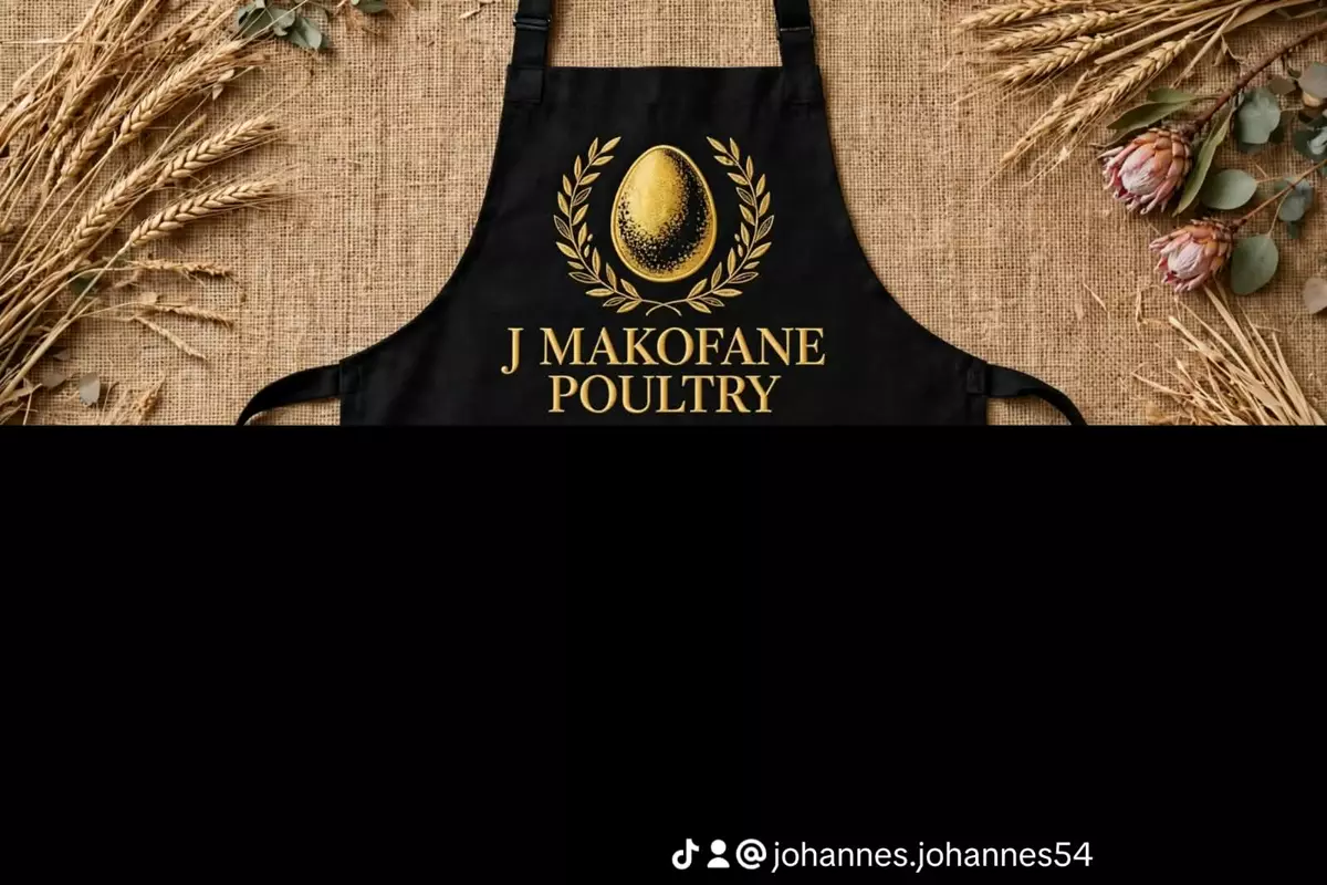Black apron with gold poultry logo on burlap background with wheat stalks